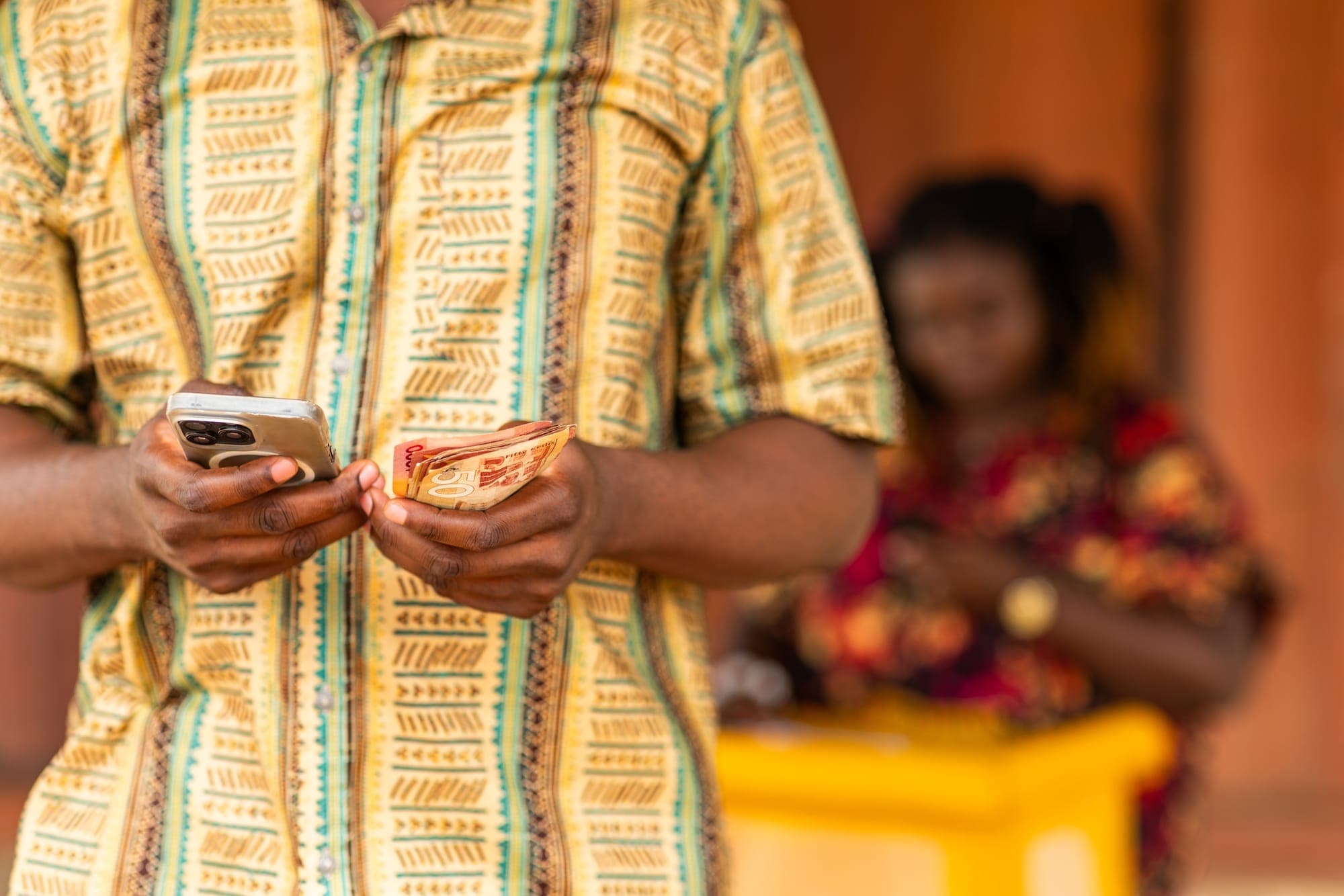 An entrepreneur counting cash beside a mobile phone